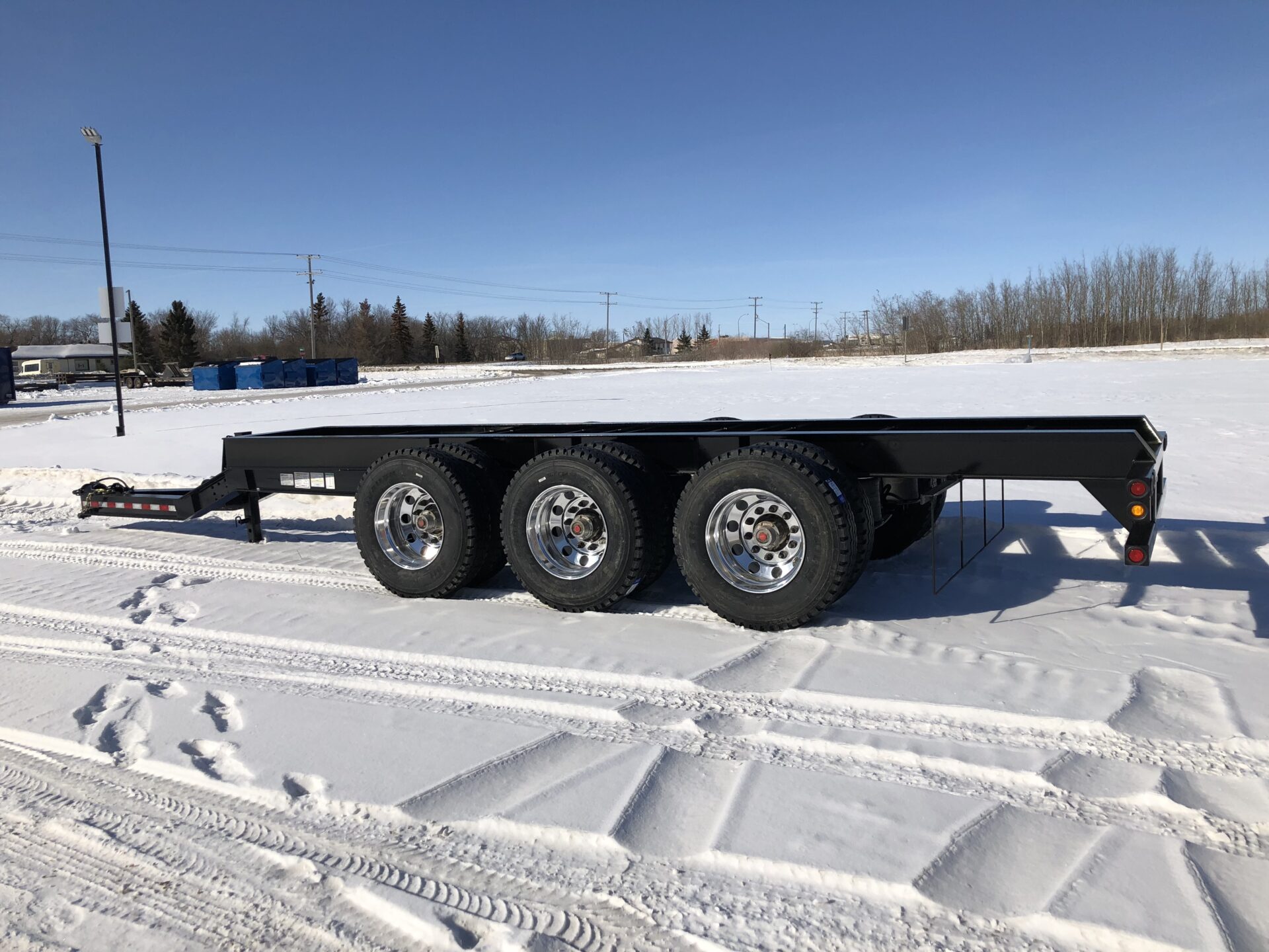 An empty pup trailer sitting in the snow.